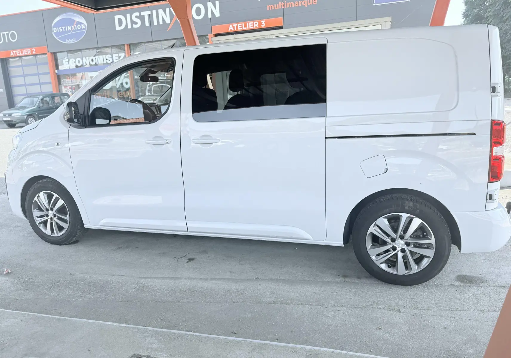 Peugeot Expert cabine approfondie blanc vu de profil côté gauche, avec jantes alliage et vitres teintées.