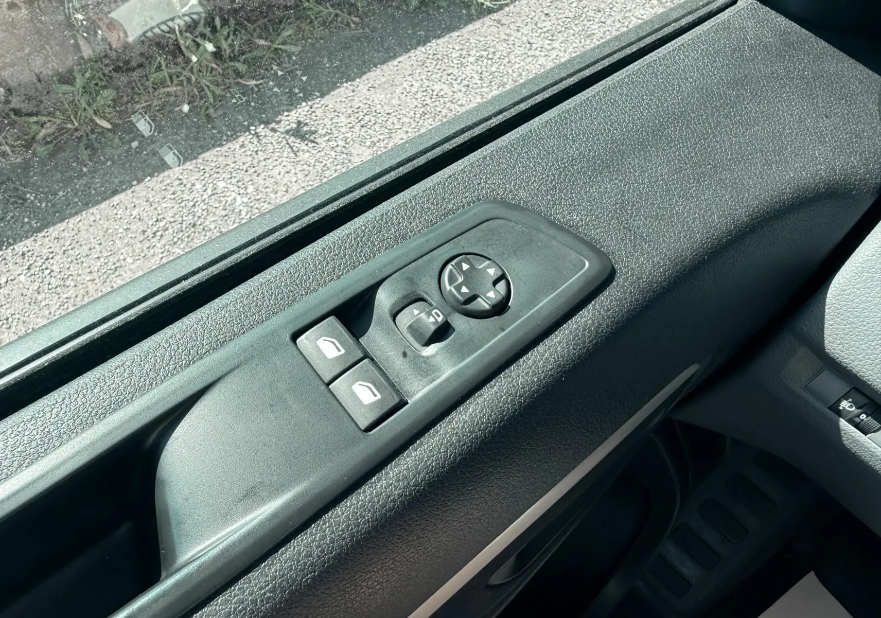 Vue rapprochée des commandes de réglage des rétroviseurs et des vitres côté conducteur du Peugeot Expert cabine approfondie blanc.