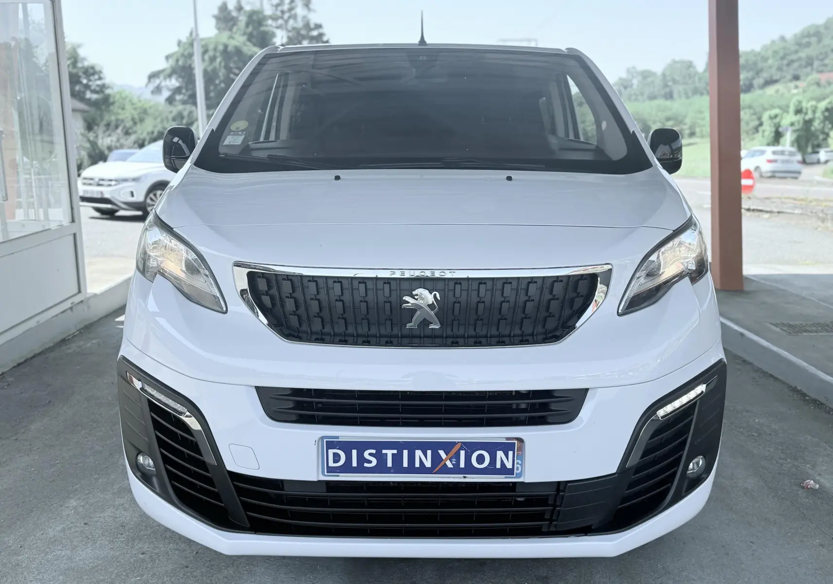 Vue de face d'un Peugeot Expert cabine approfondie blanc avec calandre noire et plaque Distinxion.