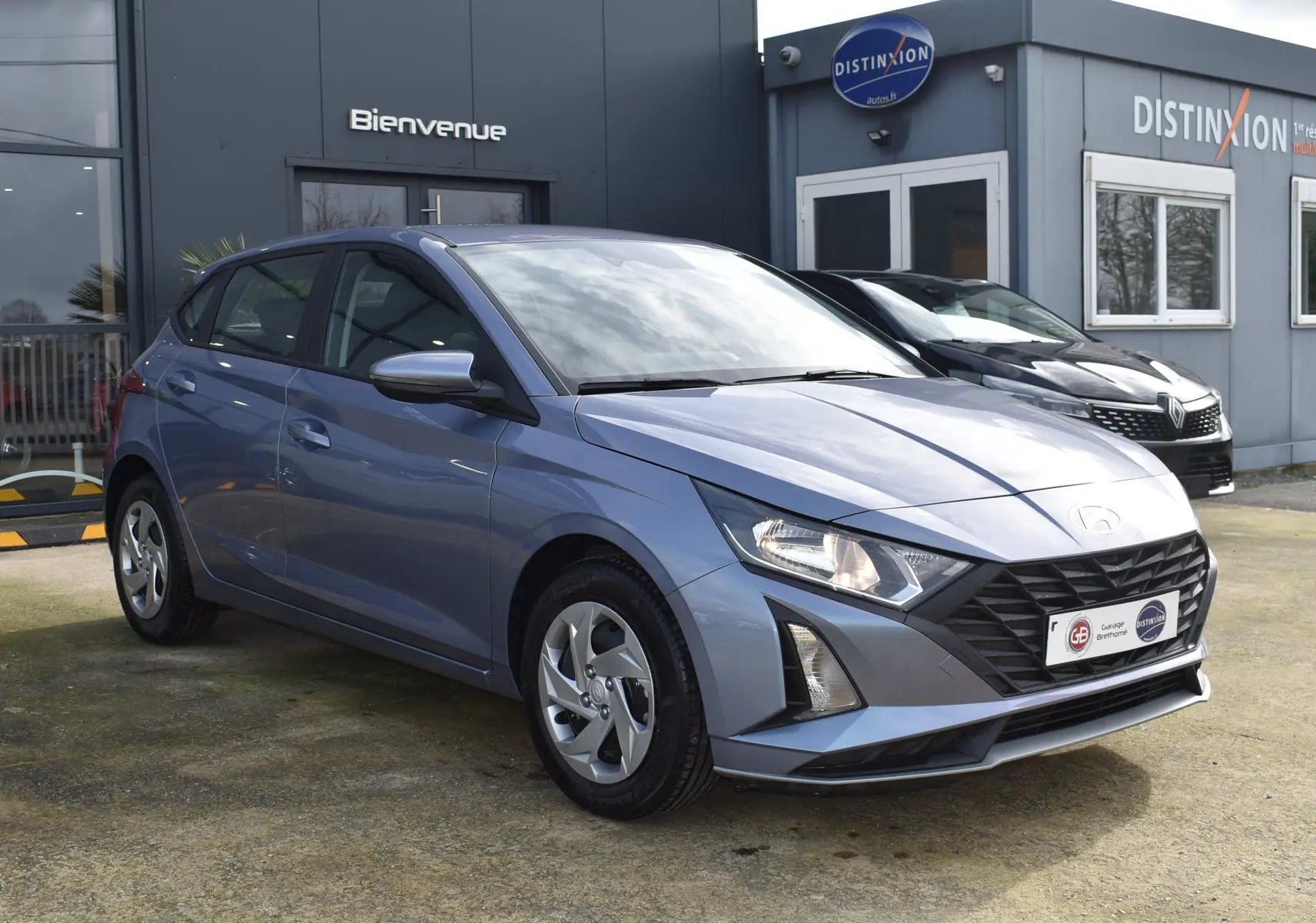 Vue 3/4 avant gauche d'une Hyundai i20 1.2 79 Intuitive bleu clair avec calandre noire et jantes alliage.