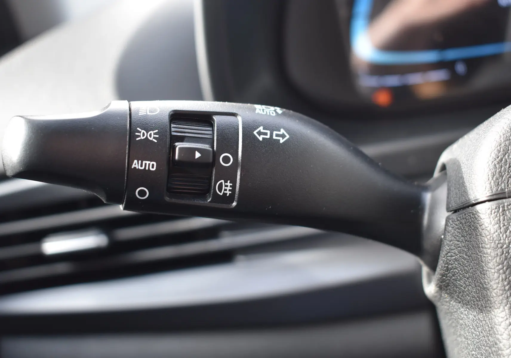 Gros plan sur la commande de clignotants et phares à gauche du volant dans l’habitacle d’une Hyundai i20 2025.