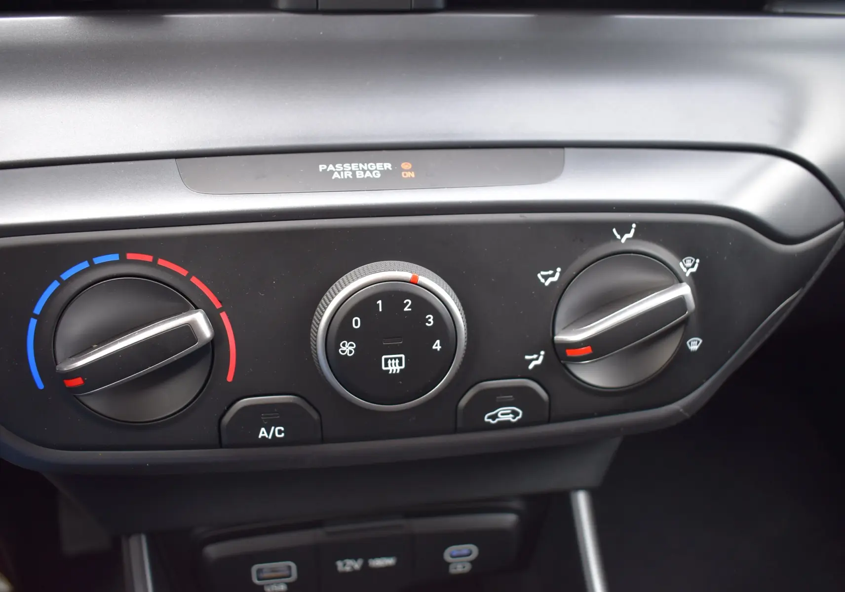 Gros plan sur les commandes de climatisation de la Hyundai i20 1.2 79 Intuitive, avec réglages manuels et indicateurs colorés.