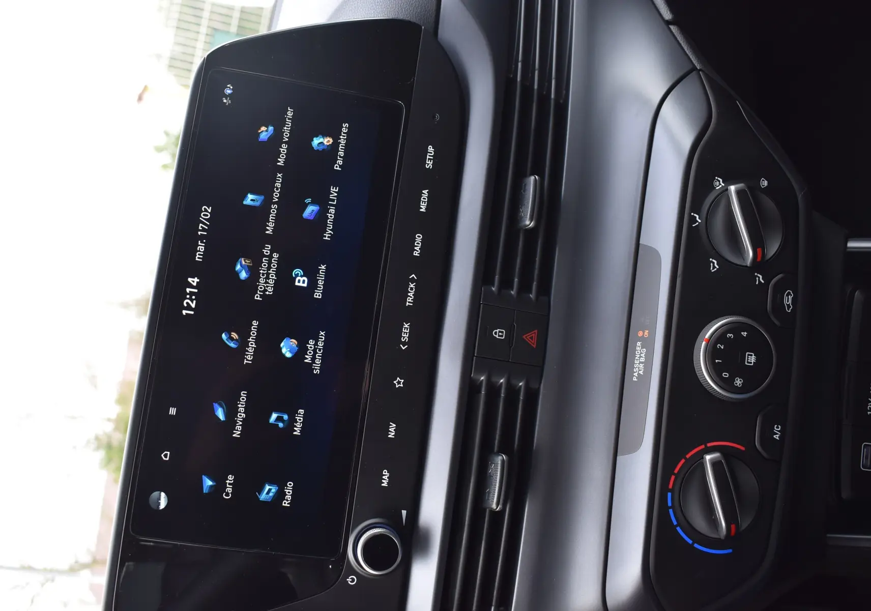 Vue rapprochée de la console centrale de la Hyundai i20 2025, écran tactile noir et commandes de climatisation grises.