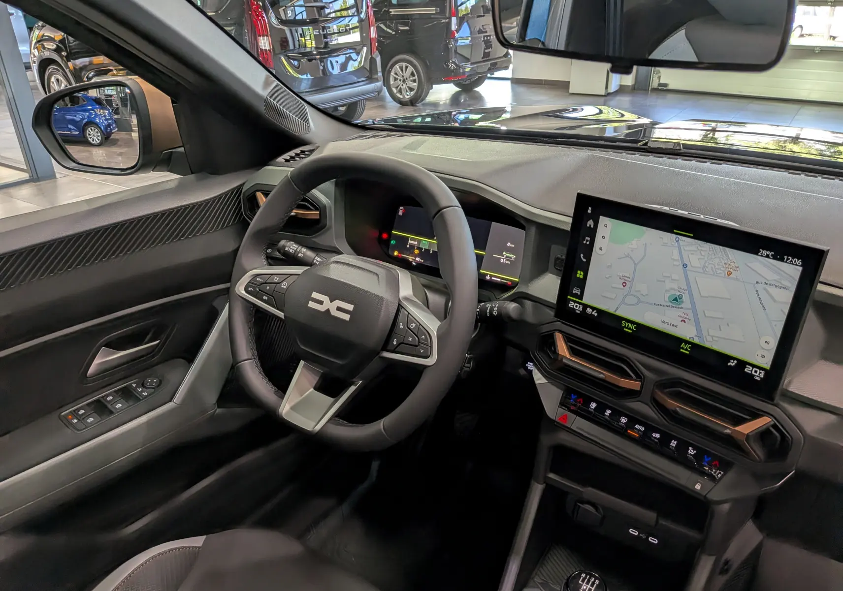 Vue intérieure côté conducteur du Dacia Bigster 2026, tableau de bord noir avec écran tactile et volant multifonction.