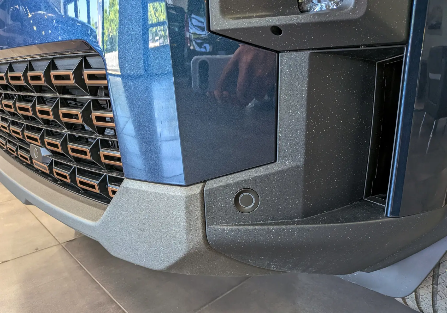 Gros plan sur l’avant droit bleu indigo du Dacia Bigster 2026, mettant en valeur la calandre et le pare-chocs texturé noir.