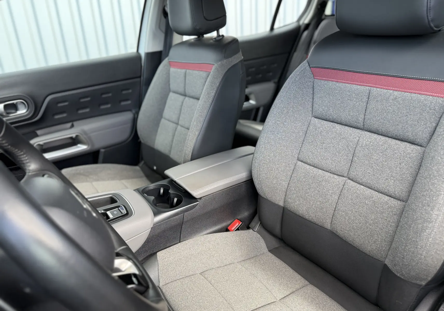 Vue intérieure rapprochée des sièges avant gris et noir avec bande rouge du Citroën C5 Aircross 2021, version Business.