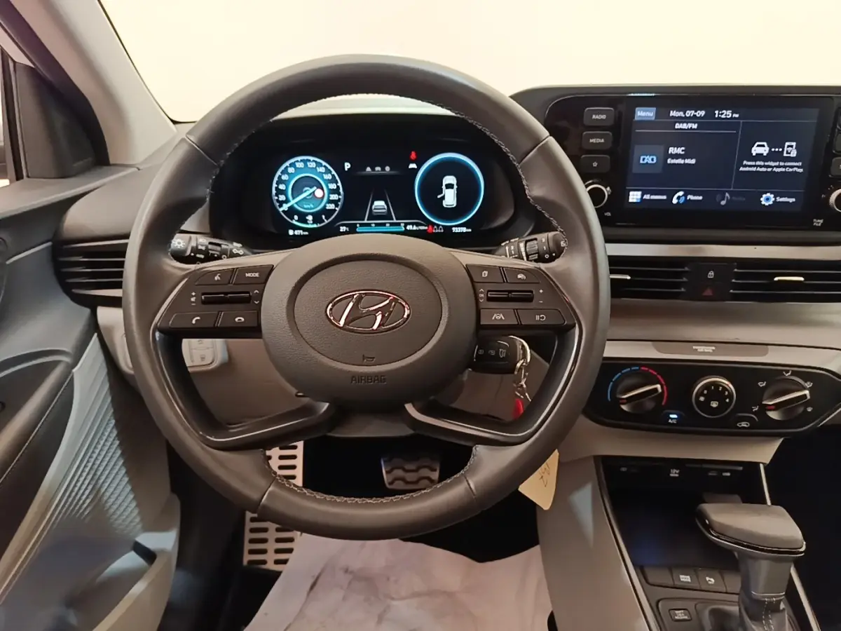 Vue intérieure centrée sur le volant cuir multifonctions et le tableau de bord digital du Hyundai Bayon 2024.