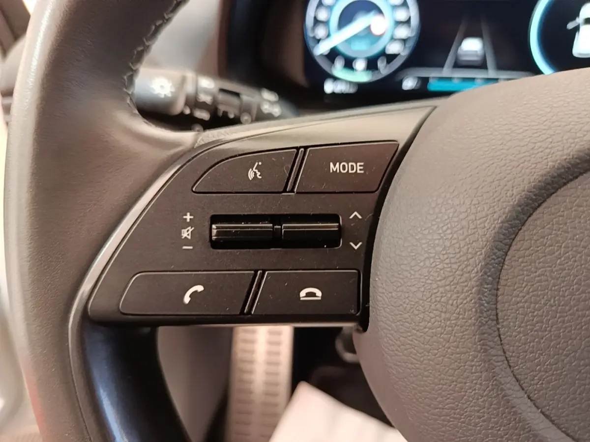 Gros plan sur les commandes gauche du volant cuir du Hyundai Bayon 2024, avec affichage numérique en arrière-plan.