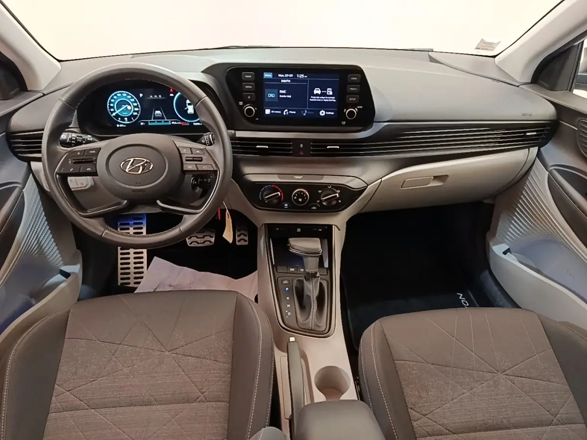 Intérieur de la Hyundai Bayon 2024 vu de face, tableau de bord moderne avec écran tactile et volant multifonctions noir.