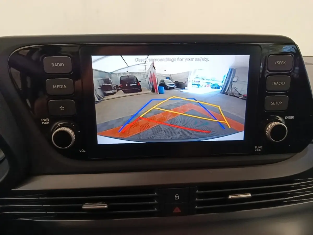 Écran tactile central montrant la caméra de recul avec guidage coloré dans un Hyundai Bayon 2024 blanc.