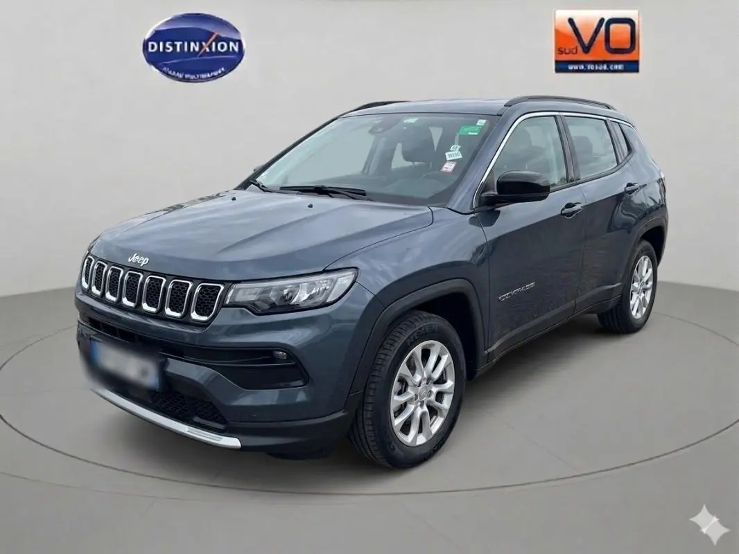 Jeep Compass bleu en vue 3/4 avant droit, avec jantes alliage 18 pouces et calandre distinctive à sept ouvertures.