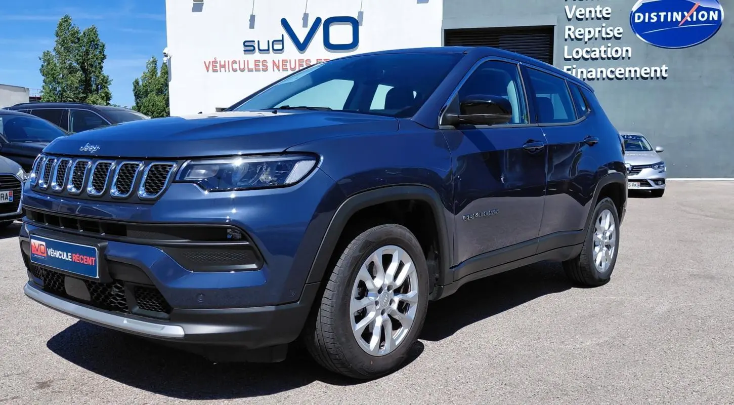 Jeep Compass bleu 3/4 avant droit, jantes alliage 18 pouces, calandre distinctive et phares LED visibles.