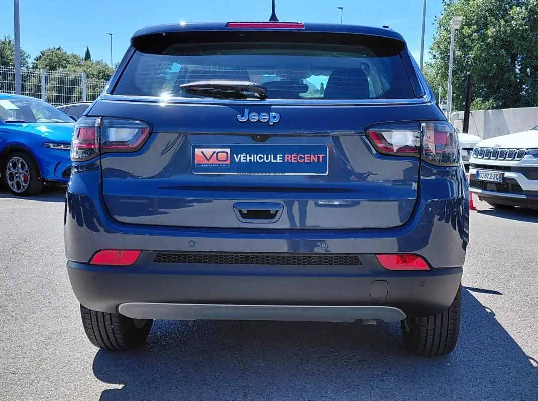 Vue arrière d’un Jeep Compass bleu 2025 avec feux LED et plaque « Véhicule récent » visible au centre.