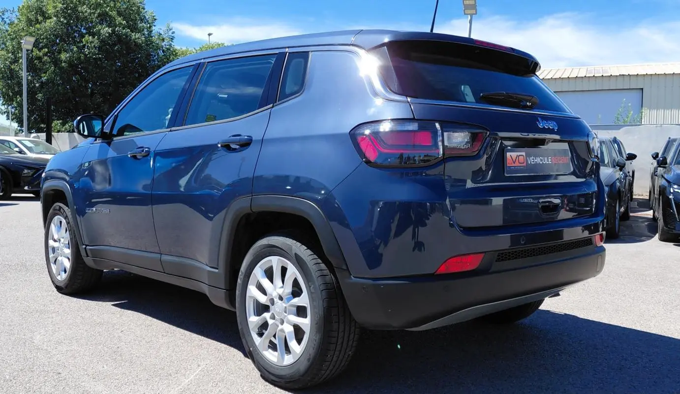 Jeep Compass bleu 3/4 arrière droit, jantes alliage 18 pouces, feux arrière LED et vitres teintées.