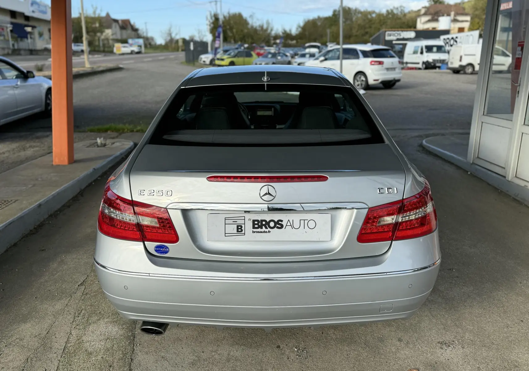 Vue arrière d'une Mercedes Classe E 250 CDI gris métallisé avec feux rouges et logo central visible.