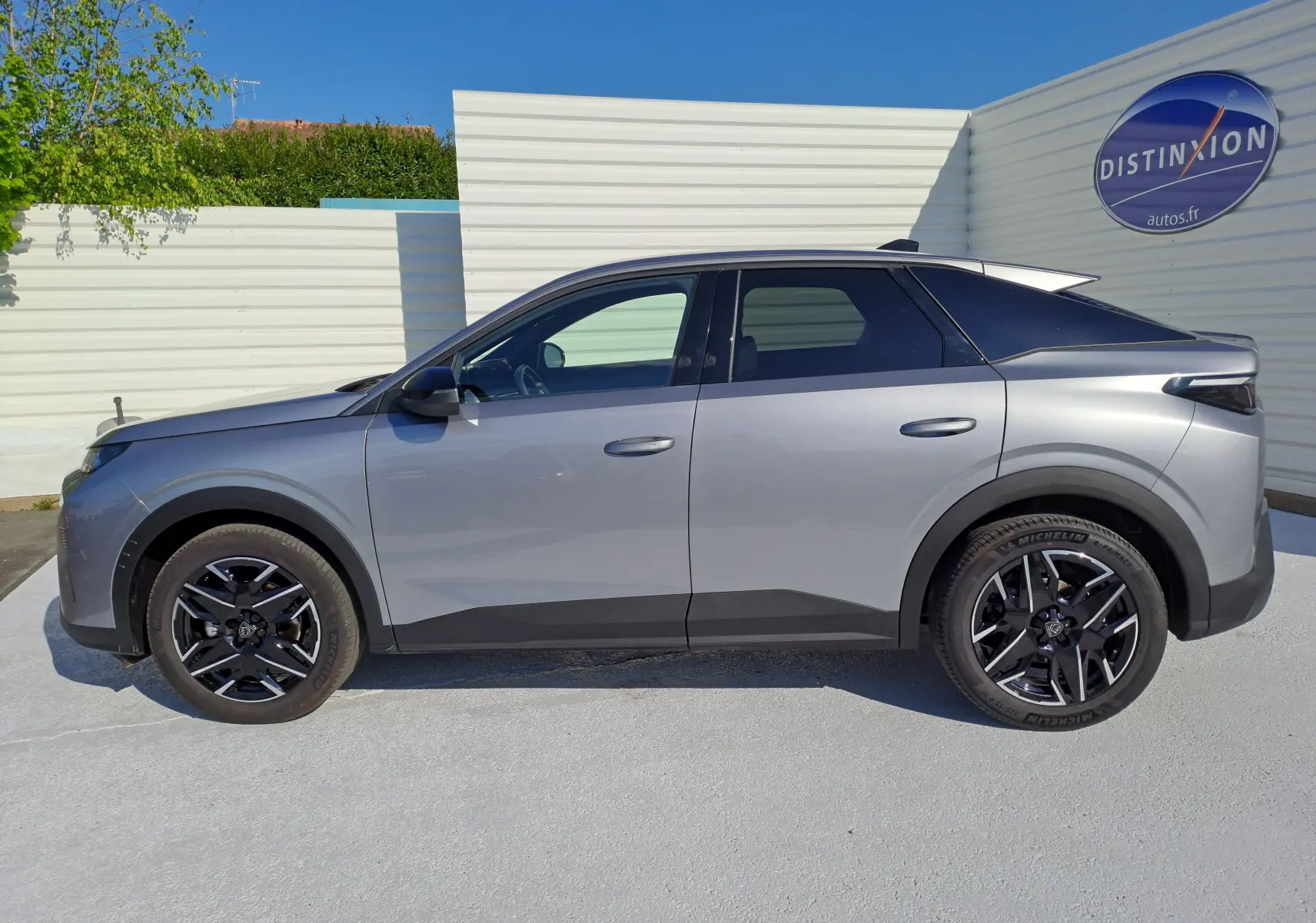 Profil côté gauche d'un Peugeot 3008 gris Artense 2024 avec jantes noires et toit noir contrasté.