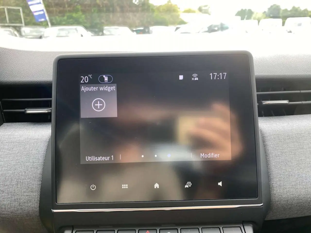 Écran tactile central de la Renault Clio 2025 avec tableau de bord gris et aérateurs latéraux visibles.