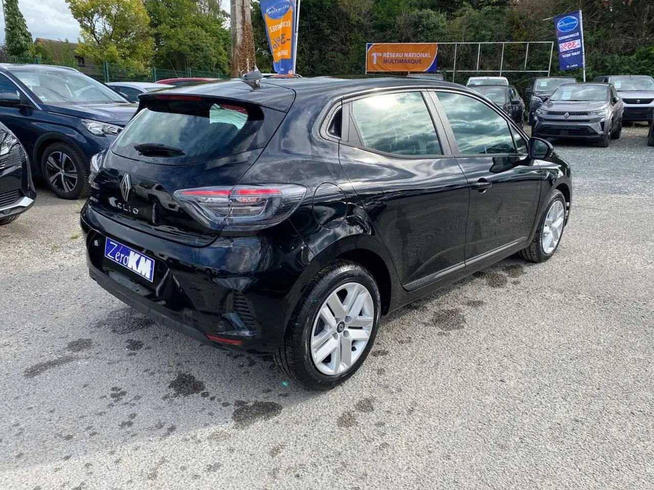 Vue 3/4 arrière droite d'une Renault Clio noire étoile 2025 avec feux LED et jantes alliage visibles.
