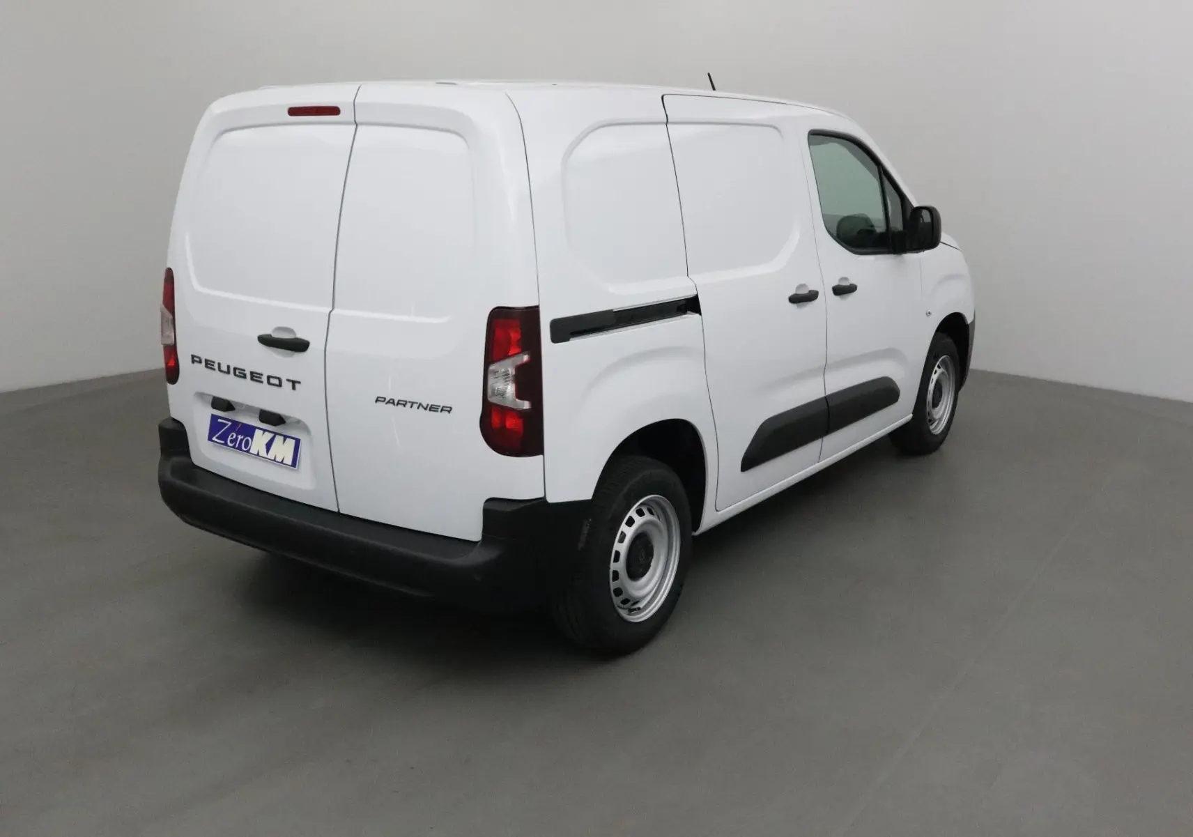 Vue 3/4 arrière droite d’un utilitaire Peugeot Partner blanc avec portes arrière battantes et bandeau noir latéral.