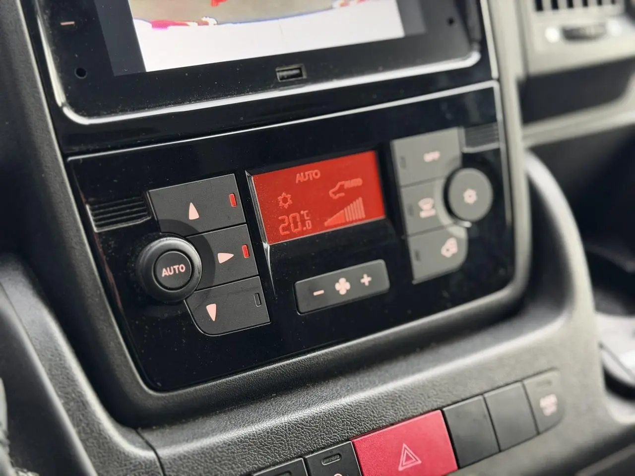 Gros plan sur la console centrale noire de l’Opel Movano Fourgon 2024, affichant la climatisation automatique à 20°C.