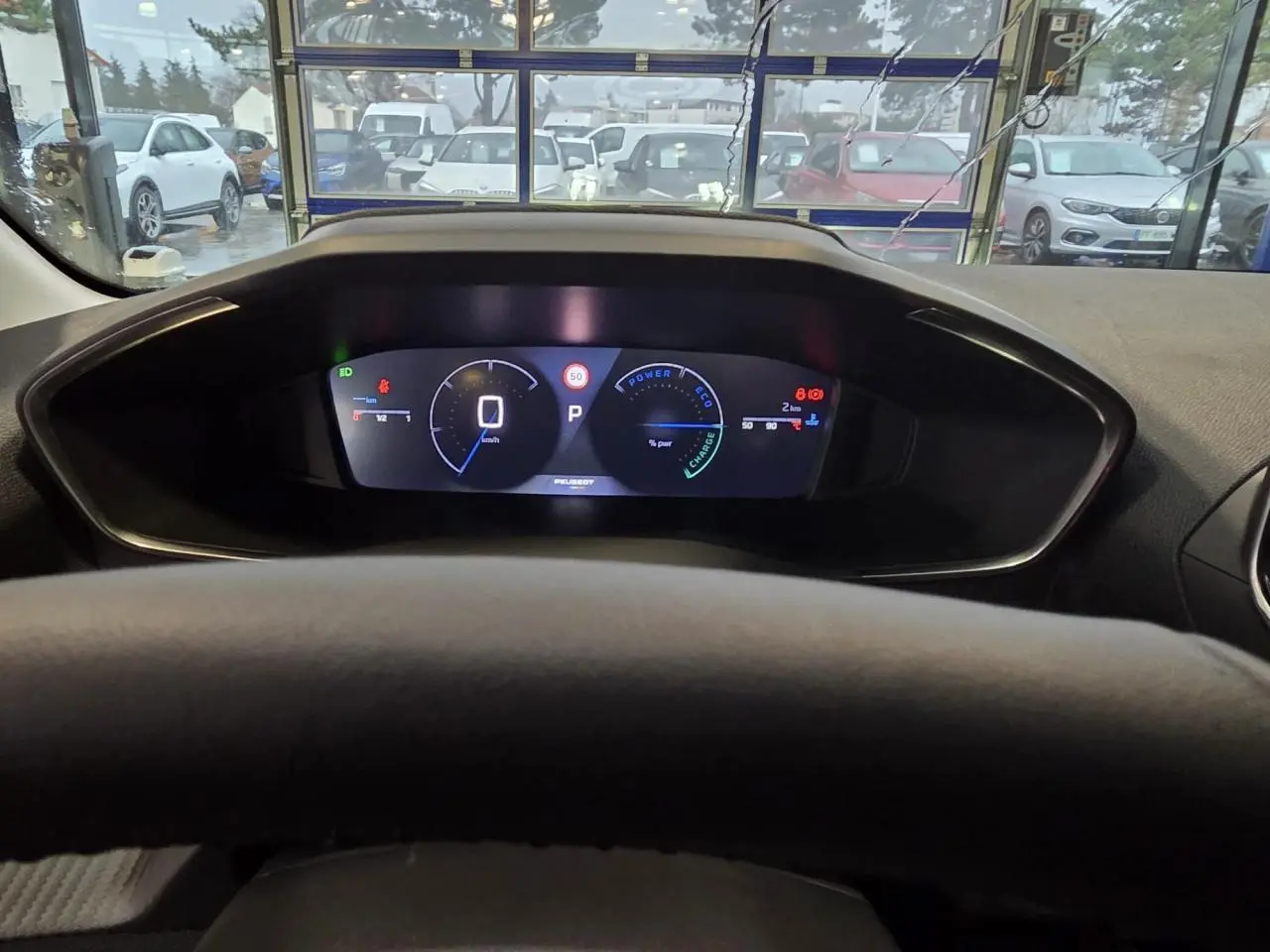 Vue intérieure du combiné numérique du tableau de bord de la Peugeot 208 hybride noire, affichage digital clair.