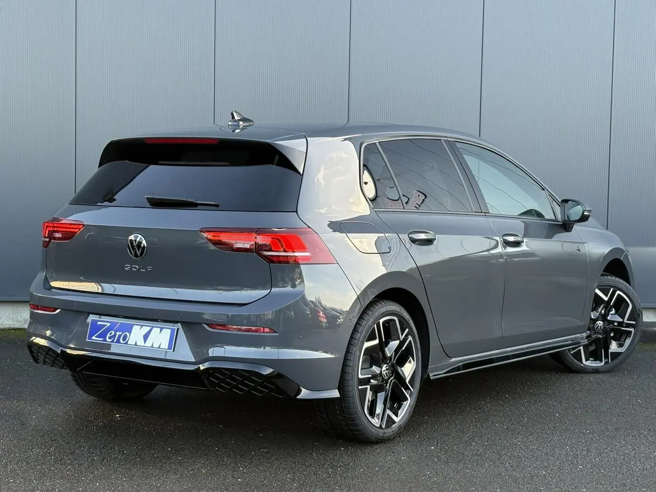 Volkswagen Golf VIII R-Line gris dauphin vue 3/4 arrière droit avec jantes alliage 18 pouces et toit ouvrant panoramique.