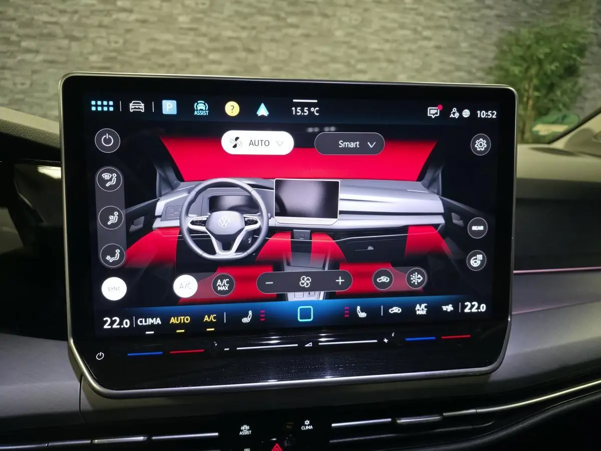 Écran tactile central affichant le tableau de bord digital d'une Volkswagen Golf VIII rouge, vue de face intérieure.