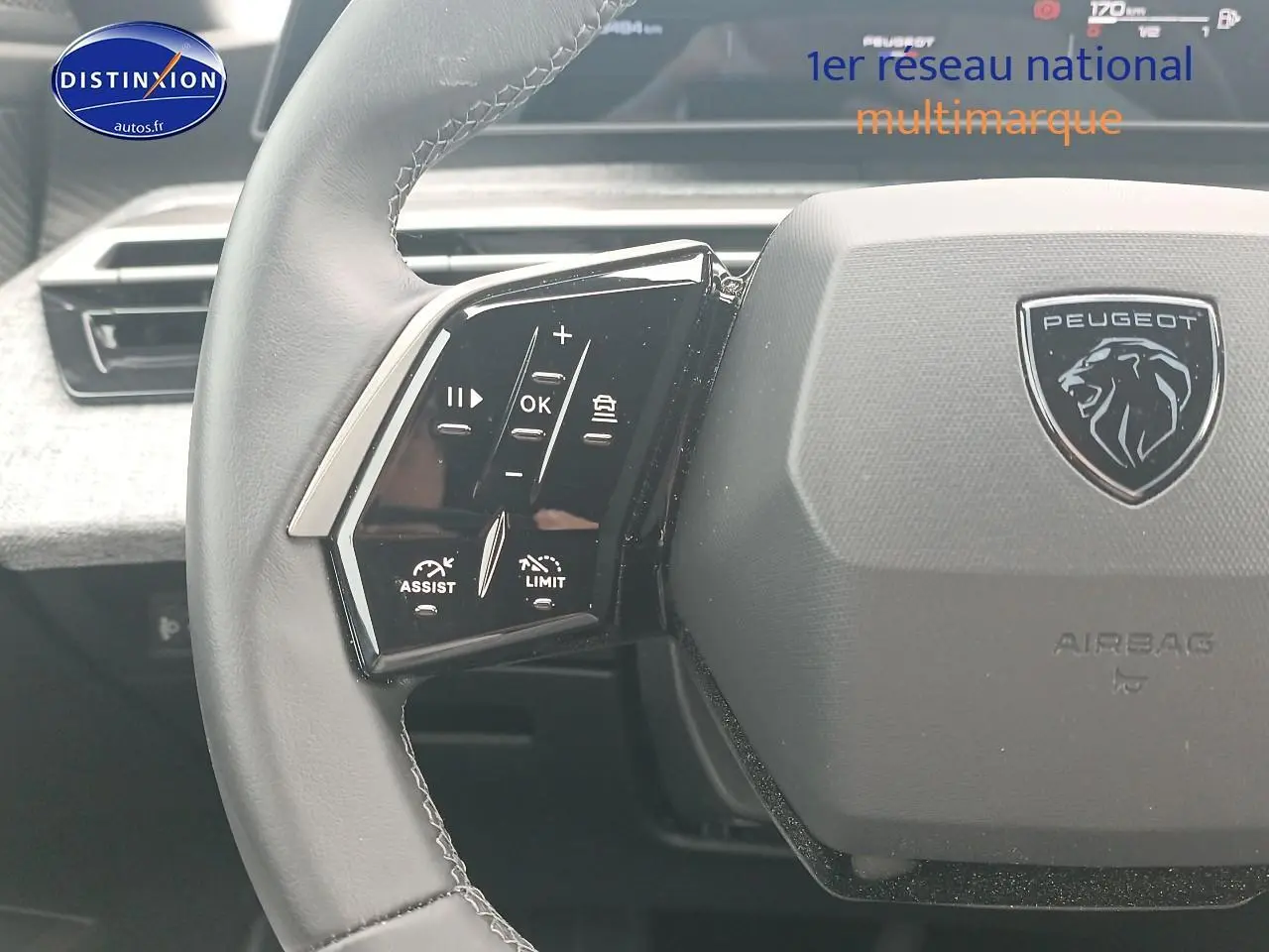 Vue rapprochée du volant cuir multifonction gris du Peugeot 3008 1.2 hybrid 145 allure e-dcs6 avec logo lion central.