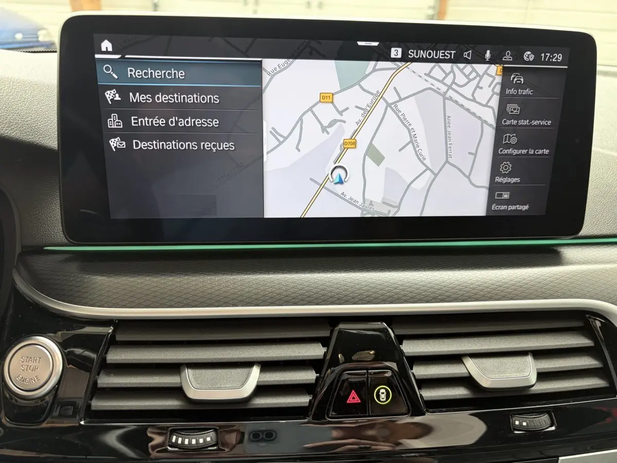 Écran tactile central de navigation de la BMW Série 5 Touring 530e 2023, vue intérieure du tableau de bord.
