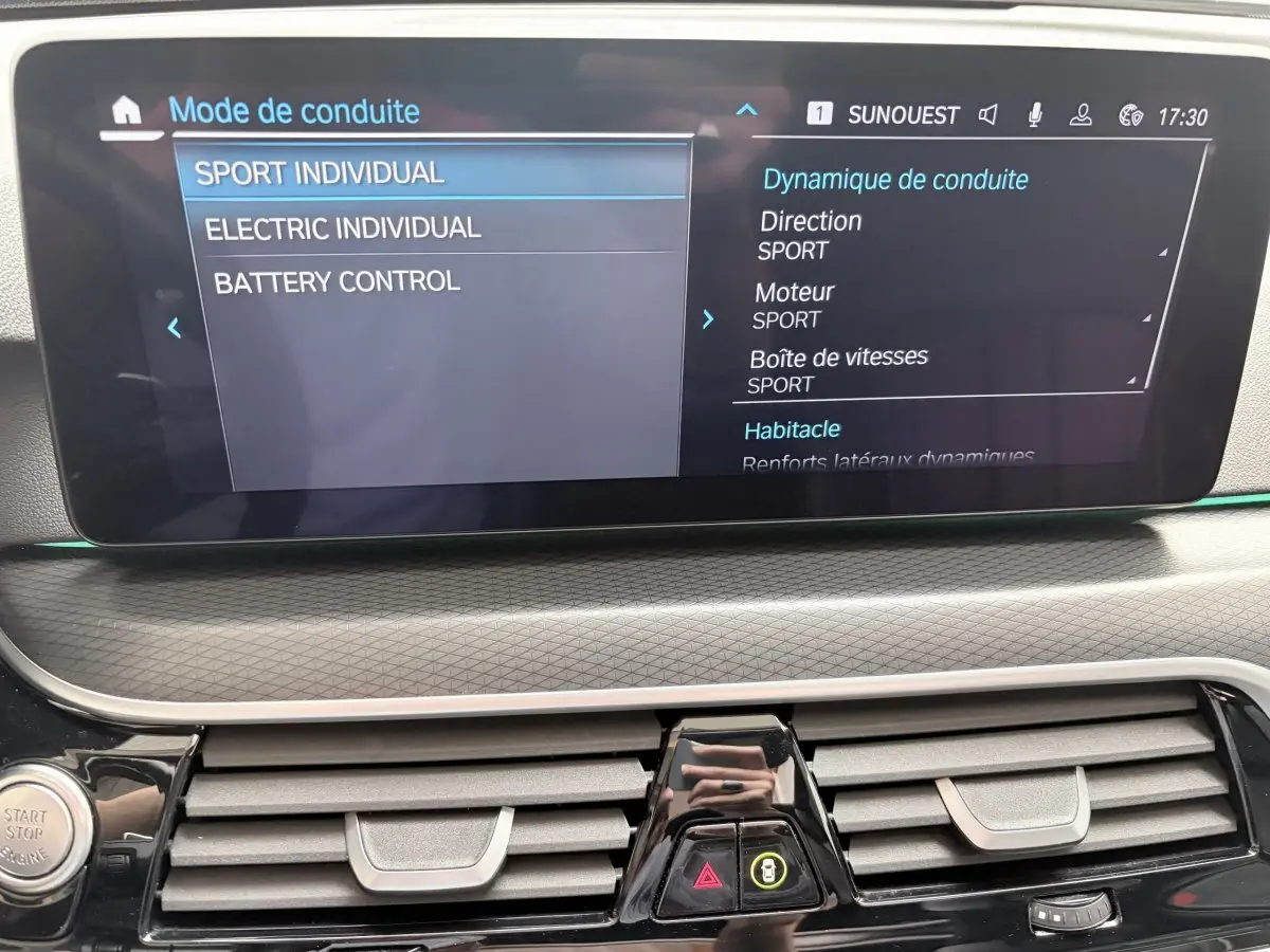 Écran tactile central affichant les modes de conduite dans l’habitacle d’une BMW Série 5 Touring noire.