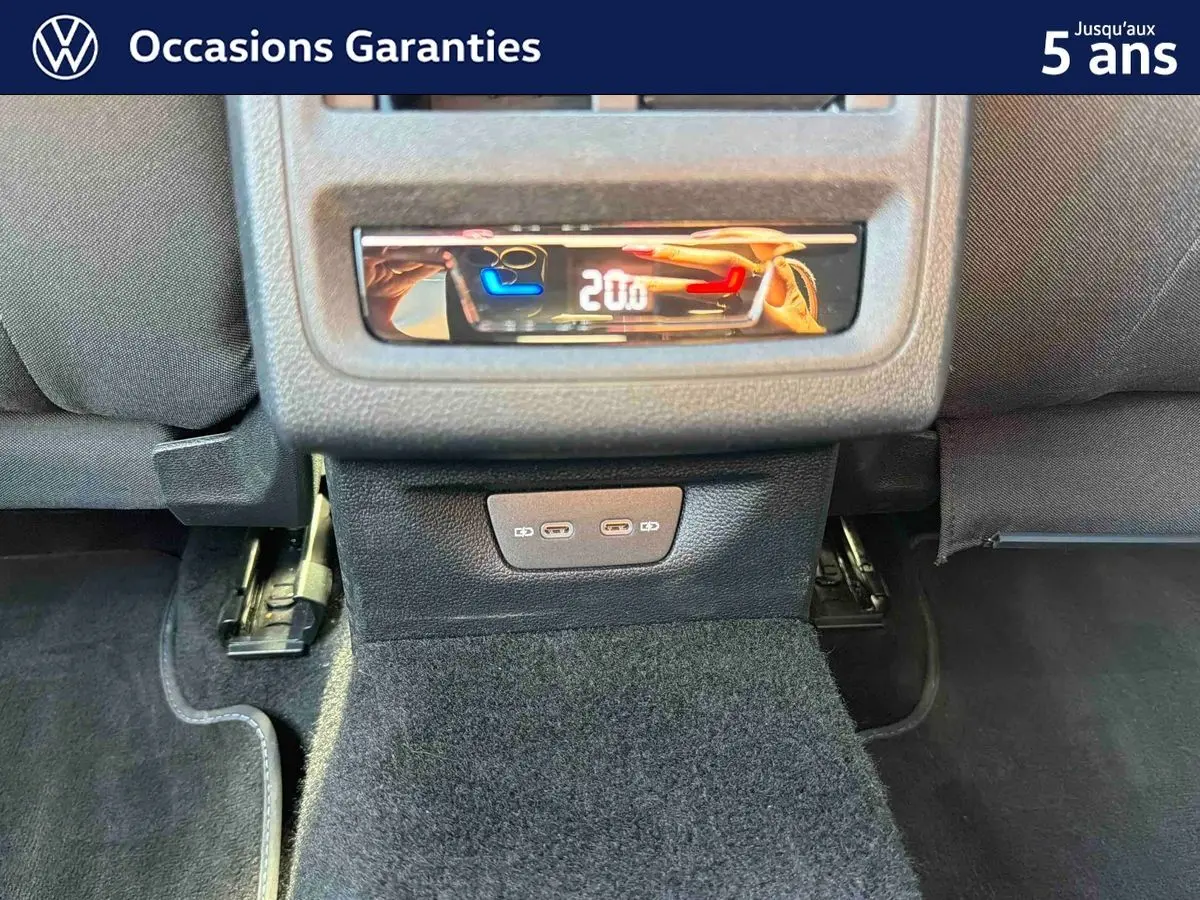 Panneau de commande de climatisation arrière et deux ports USB-C dans l'habitacle d'une Volkswagen Golf bleue.