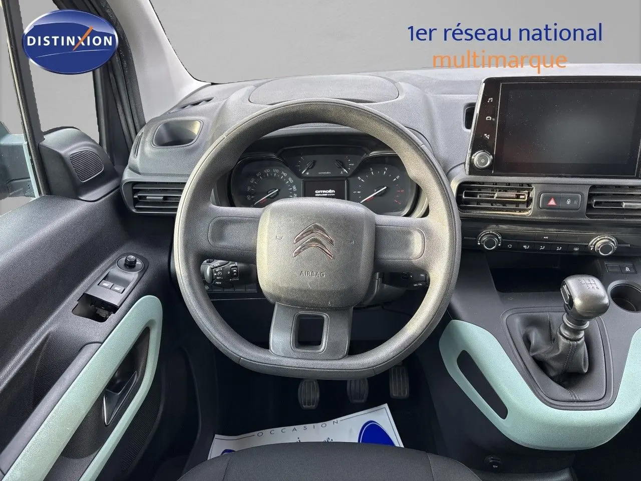 Vue intérieure centrée sur le volant et tableau de bord du Citroën Berlingo Multispace gris platinium avec boîte manuelle.