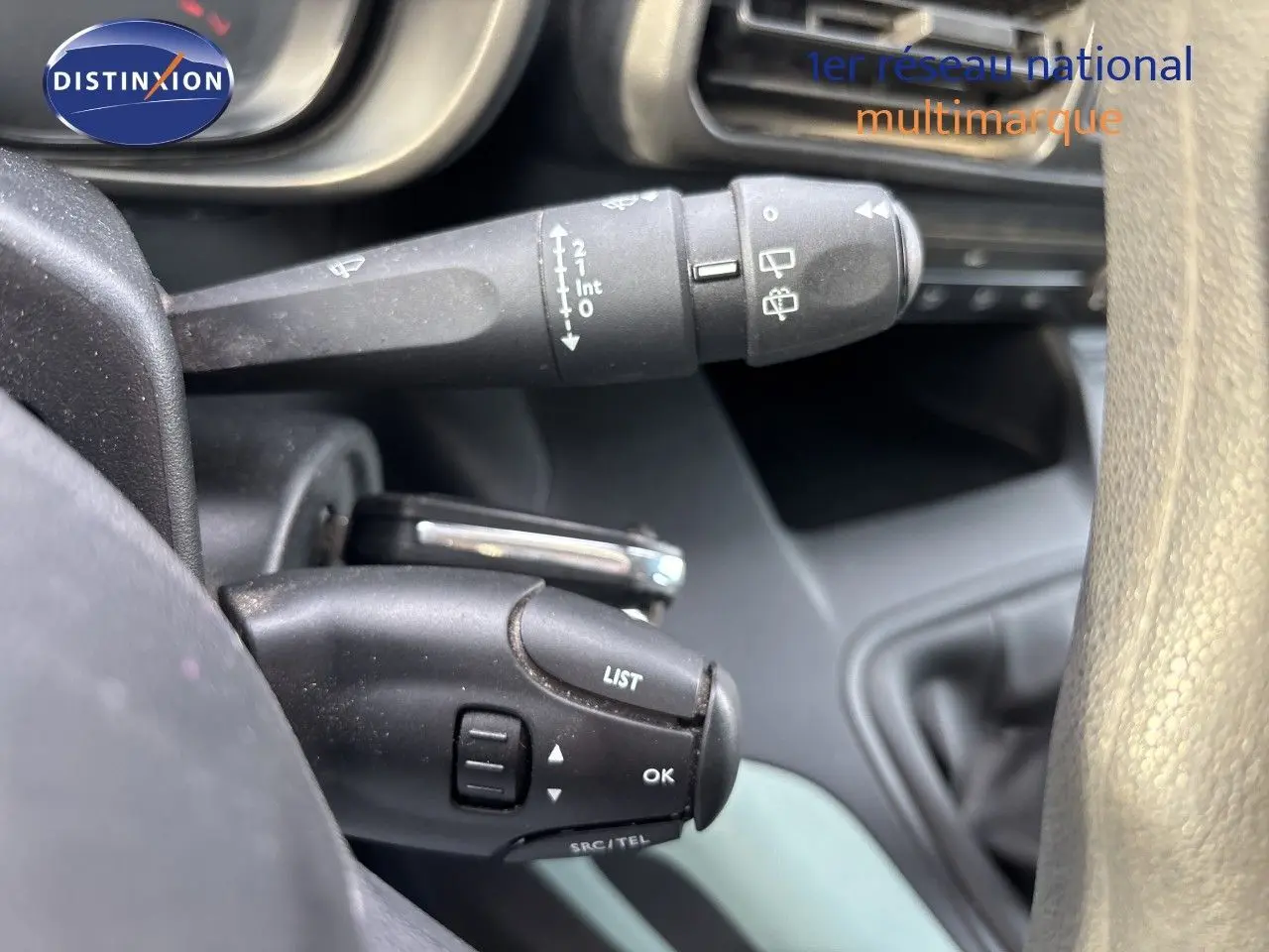 Gros plan sur les commandes au volant du Citroën Berlingo Multispace gris platinium, montrant les boutons LIST et OK.