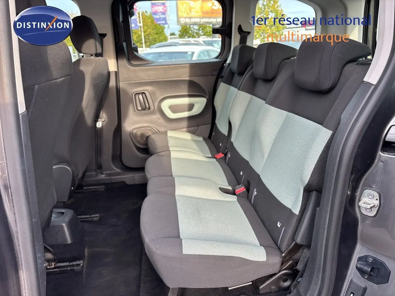 Vue intérieure côté droit du Citroën Berlingo Multispace gris platinium, montrant la banquette arrière en tissu bicolore.