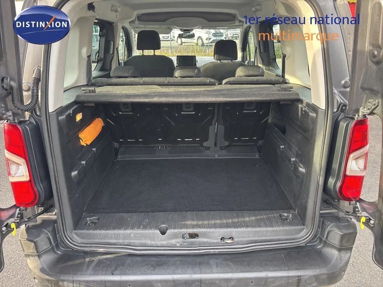 Vue arrière du coffre ouvert d’un Citroën Berlingo Multispace gris platinium, montrant l’espace de chargement et les sièges arrière.