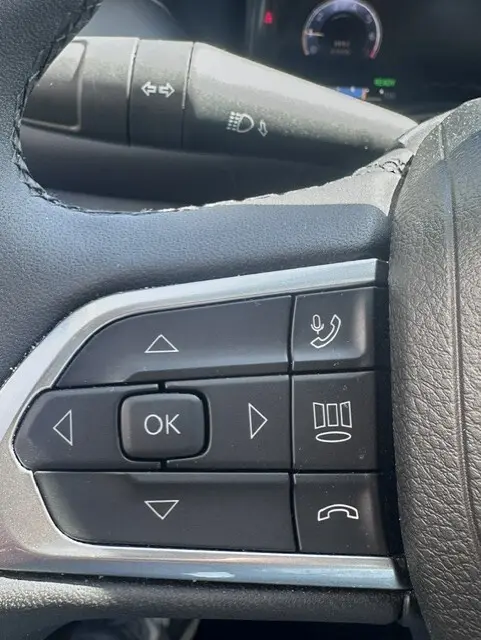 Gros plan sur les commandes multifonctions noires au volant du Jeep Compass 2025, avec boutons de navigation et appels.