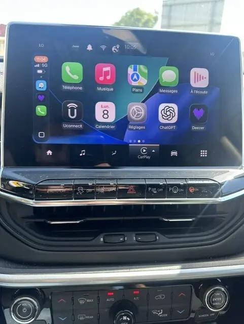 Écran tactile central du Jeep Compass 2025 affichant des applications connectées, avec commandes climatisation et multimédia en dessous.