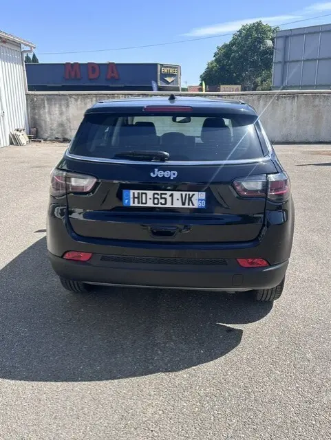 Vue arrière d'un Jeep Compass noir 2025, mettant en valeur ses feux arrière et la plaque d'immatriculation française.