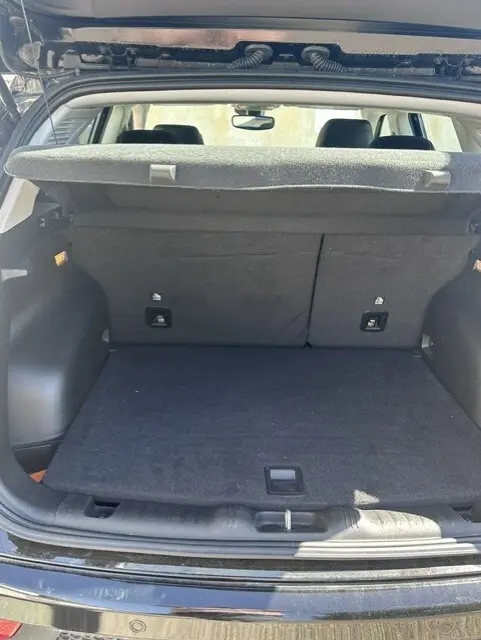 Coffre ouvert vu de l'arrière d'un Jeep Compass noir 2025, montrant un espace de chargement propre avec cache-bagages.