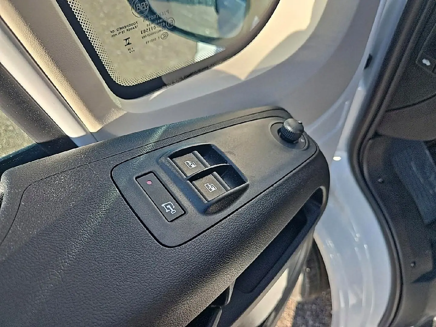 Détail des commandes des vitres électriques sur la porte avant gauche du Peugeot Boxer Fourgon blanc.