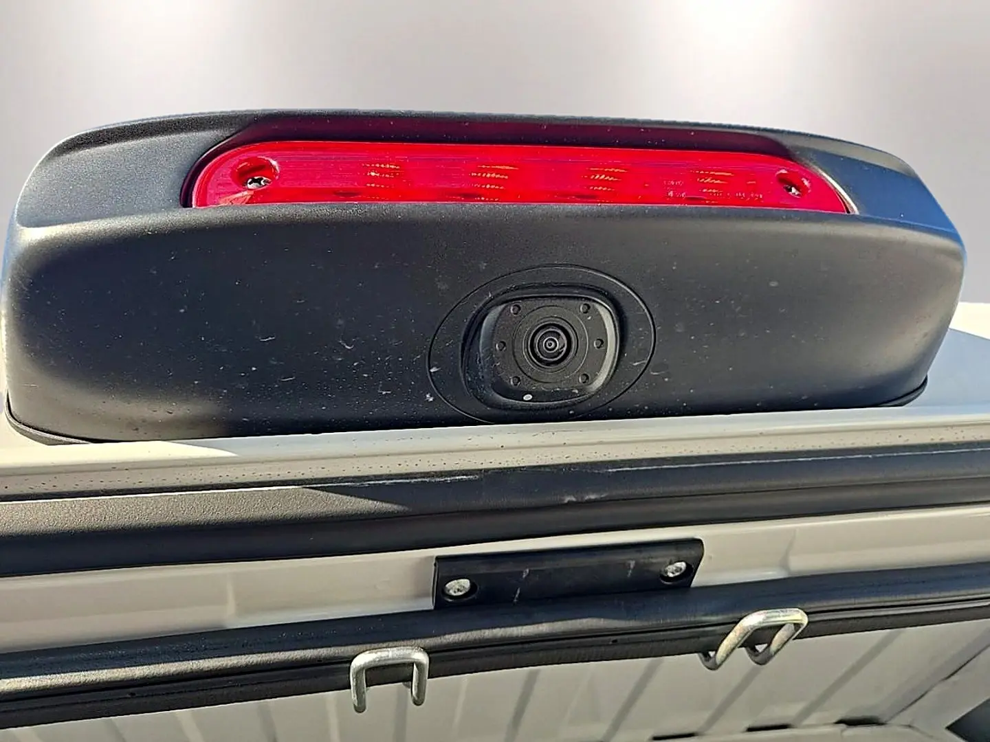 Gros plan sur la caméra de recul intégrée sous le feu stop arrière du Peugeot Boxer Fourgon blanc.