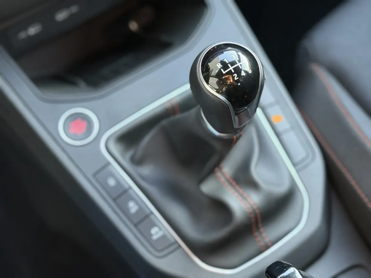 Gros plan sur le levier de vitesse manuel noir avec surpiqûres rouges de la SEAT Ibiza TSI 115 FR 2025.