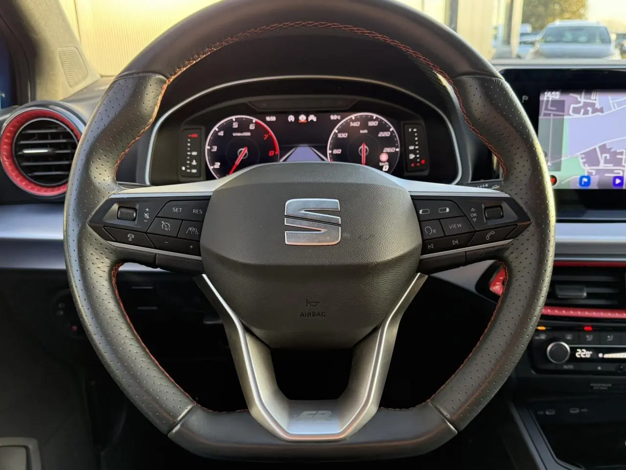 Volant en cuir perforé avec surpiqûres rouges et tableau de bord digital d'une SEAT Ibiza TSI 115 FR 2025.