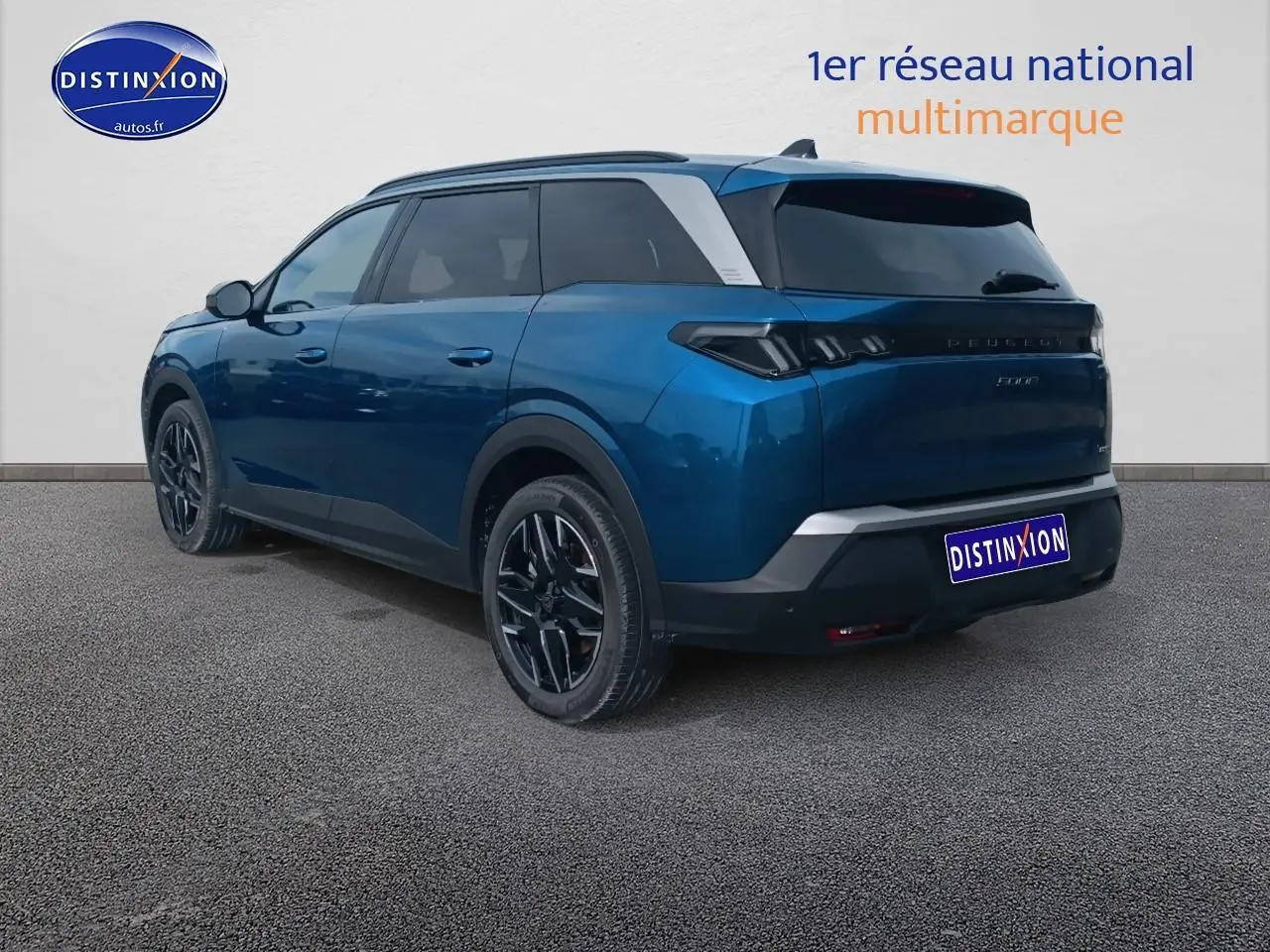 Vue 3/4 arrière droite d'un Peugeot 5008 Hybrid 145 allure e-dcs6 bleu avec vitres arrière surteintées et jantes alu noires.
