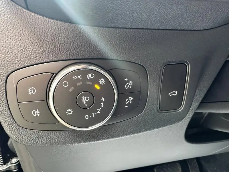 Gros plan sur le panneau de commande des phares et du coffre intérieur du Ford Puma 2024, finition ST-Line noir.