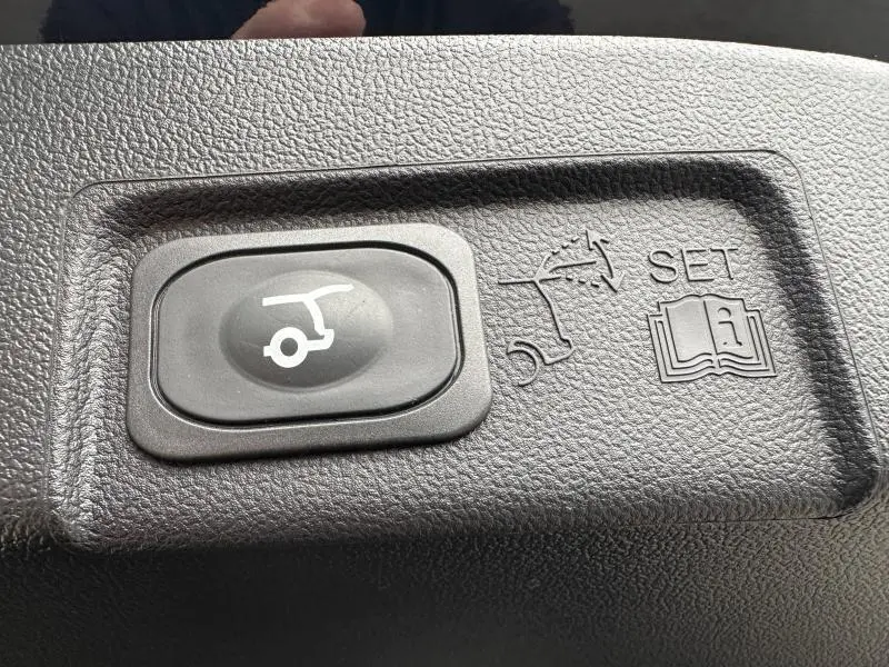 Bouton de commande de hayon électrique sur tableau de bord noir texturé d'une Ford Puma 2024 Noir Agate Métallisée.