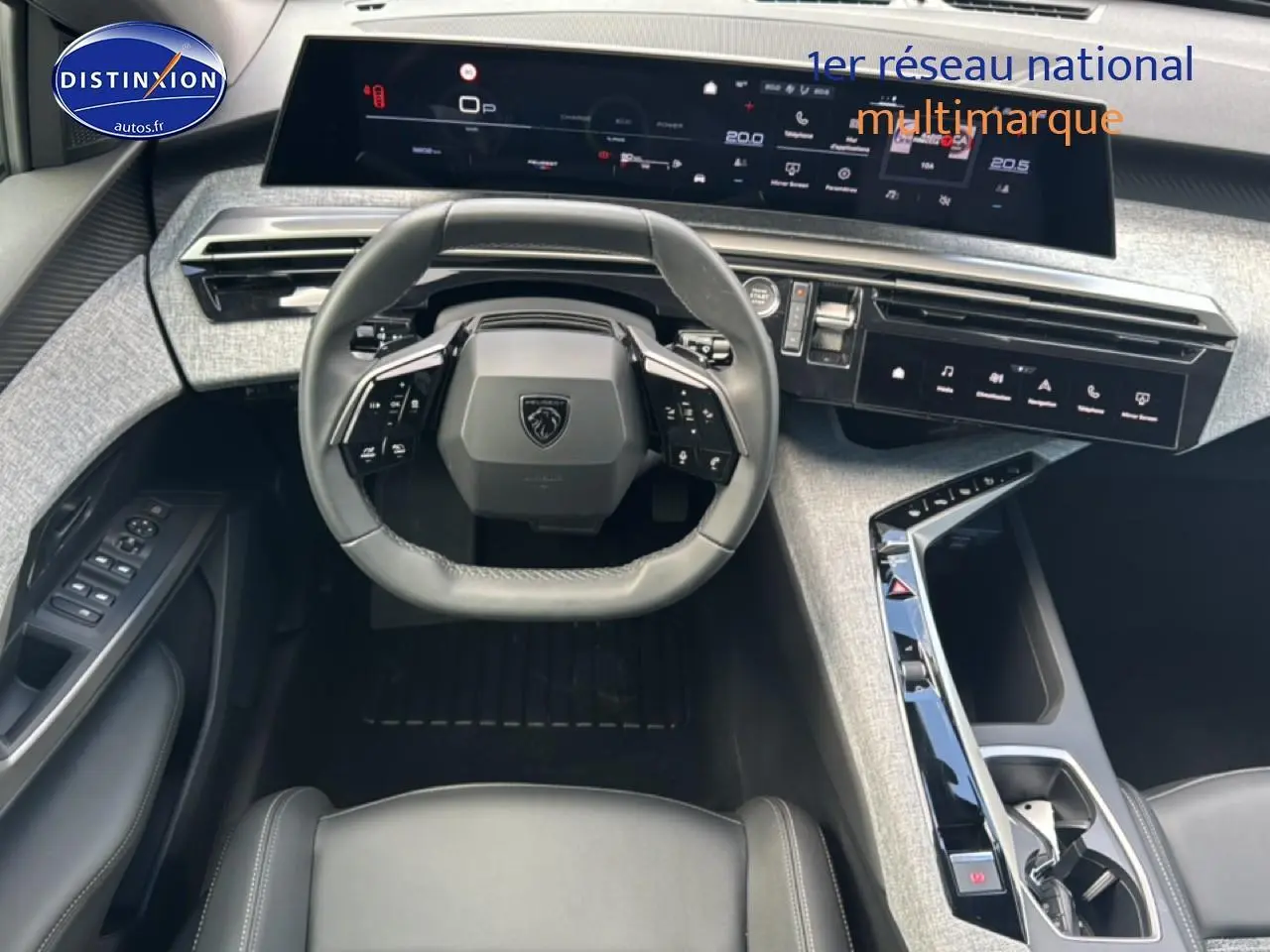 Vue intérieure avant du Peugeot 3008 2025, tableau de bord moderne gris clair avec volant cuir multifonction noir.