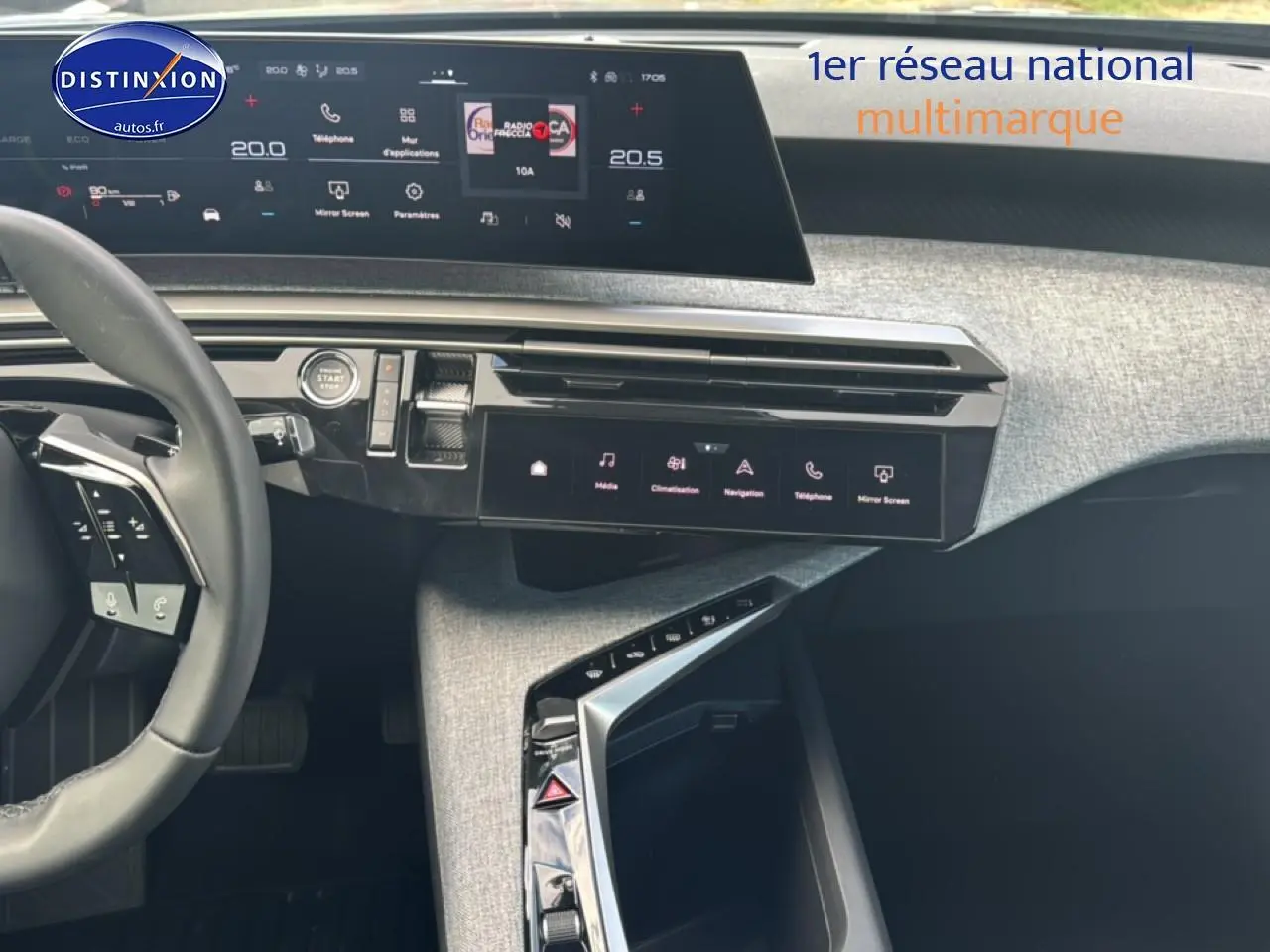 Vue intérieure du tableau de bord et console centrale du Peugeot 3008 bleu 2025, avec écran tactile et volant cuir multifonction.