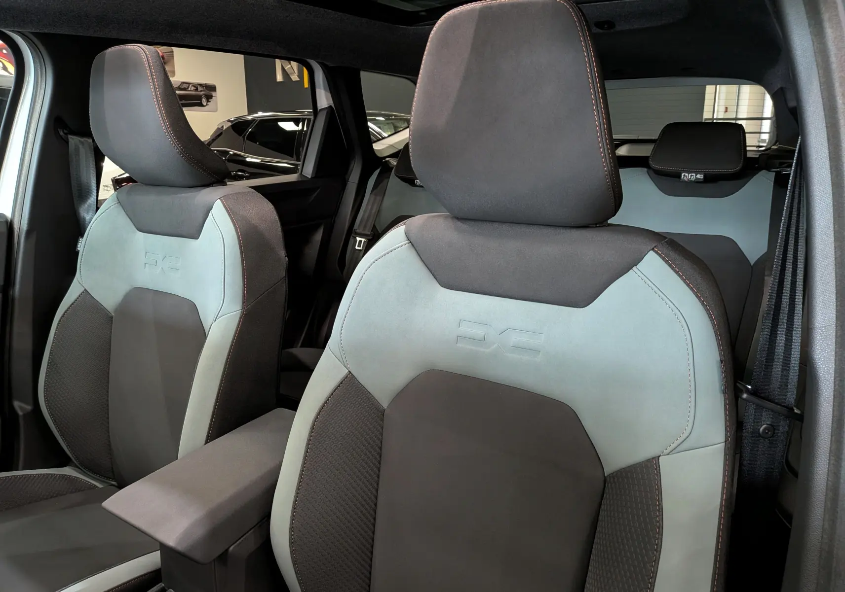 Vue intérieure rapprochée des sièges avant en tissu bi-ton gris et noir du Dacia Bigster Mild Hybrid 2026.