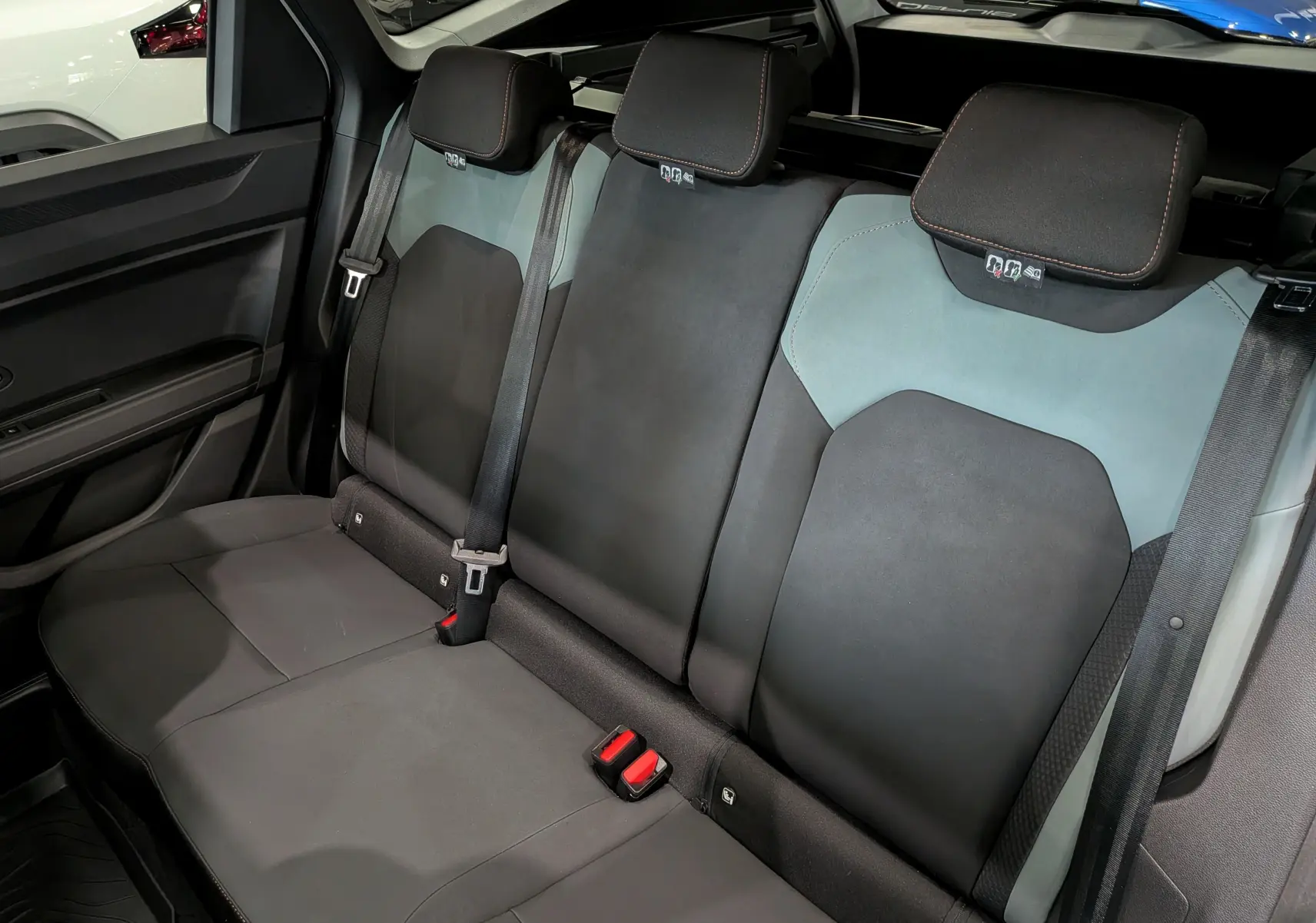 Vue intérieure des sièges arrière en tissu noir et gris du Dacia Bigster 2026, avec ceintures de sécurité visibles.